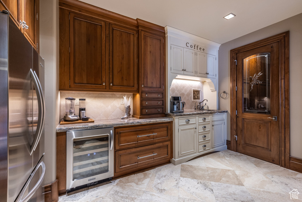 Bar featuring freestanding refrigerator, wine cooler, and decorative backsplash