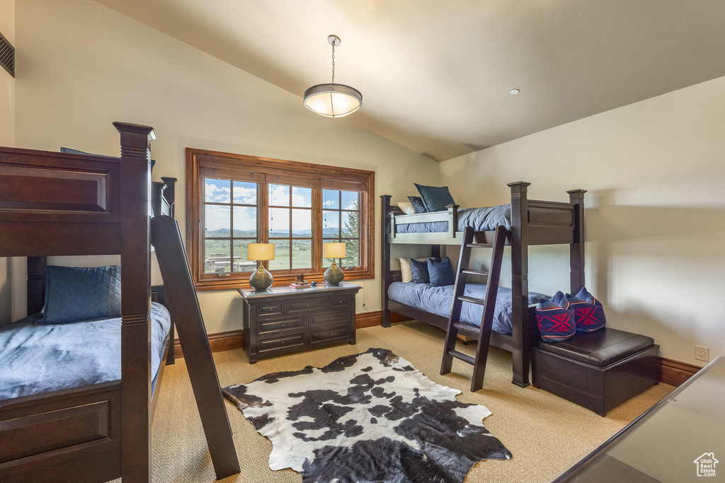 Bedroom with vaulted ceiling and light carpet