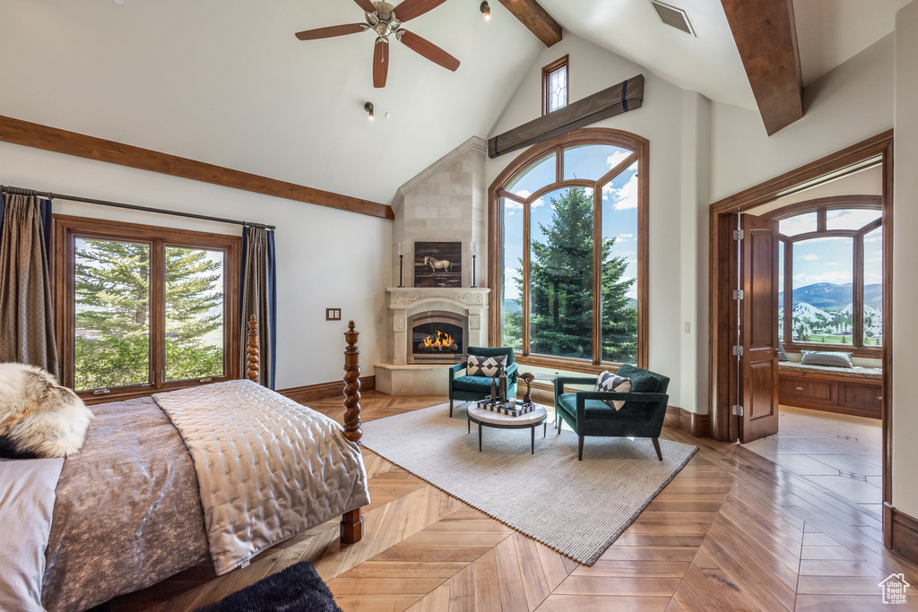 Bedroom with multiple windows, beamed ceiling, a fireplace, high vaulted ceiling, and ensuite bathroom