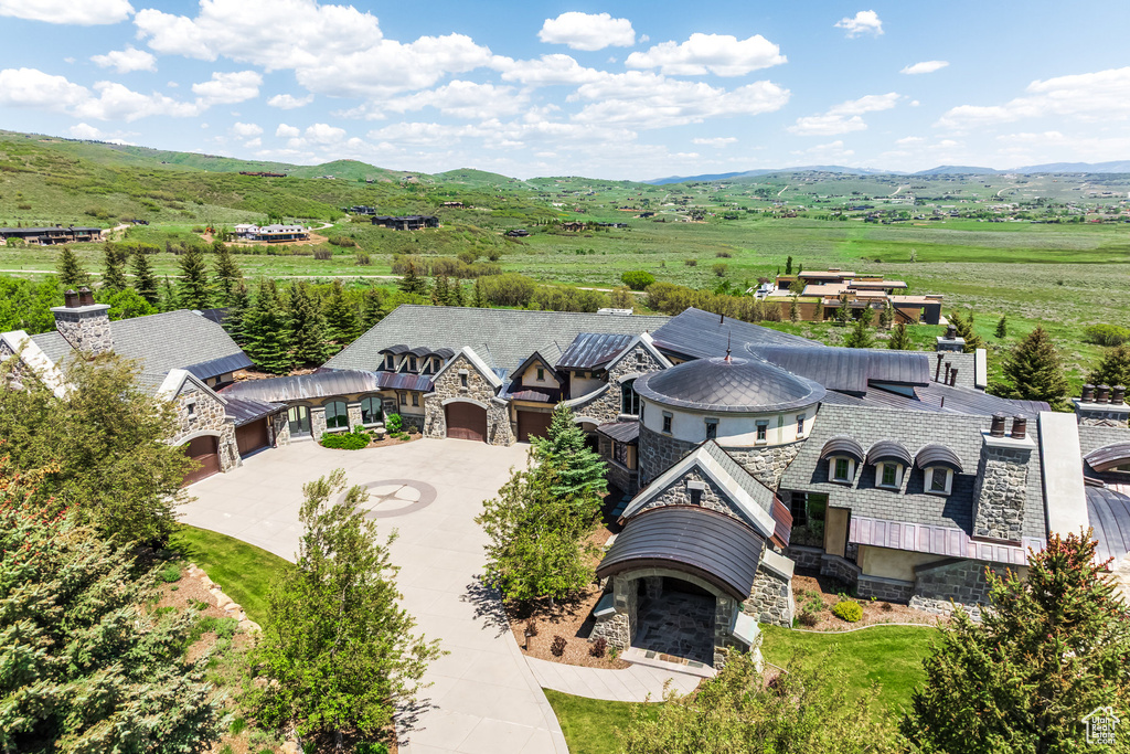 Aerial view of property and surrounding area featuring a mountainous background