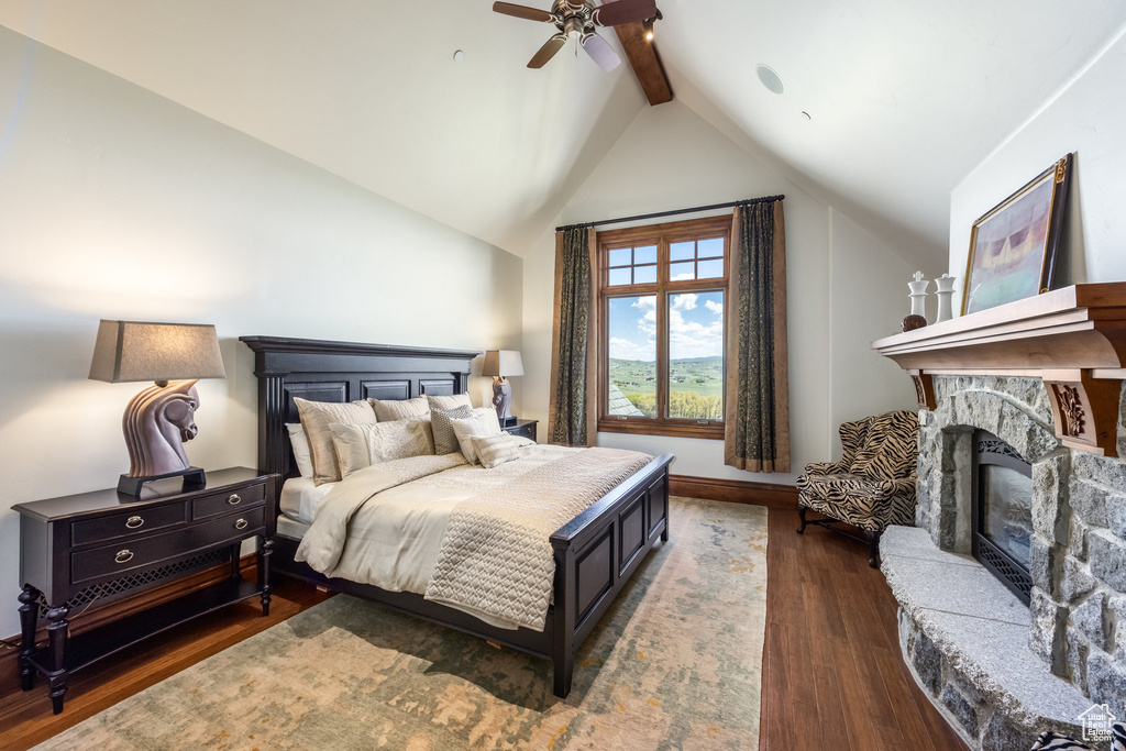 Bedroom with a fireplace, dark wood-style flooring, and a ceiling fan