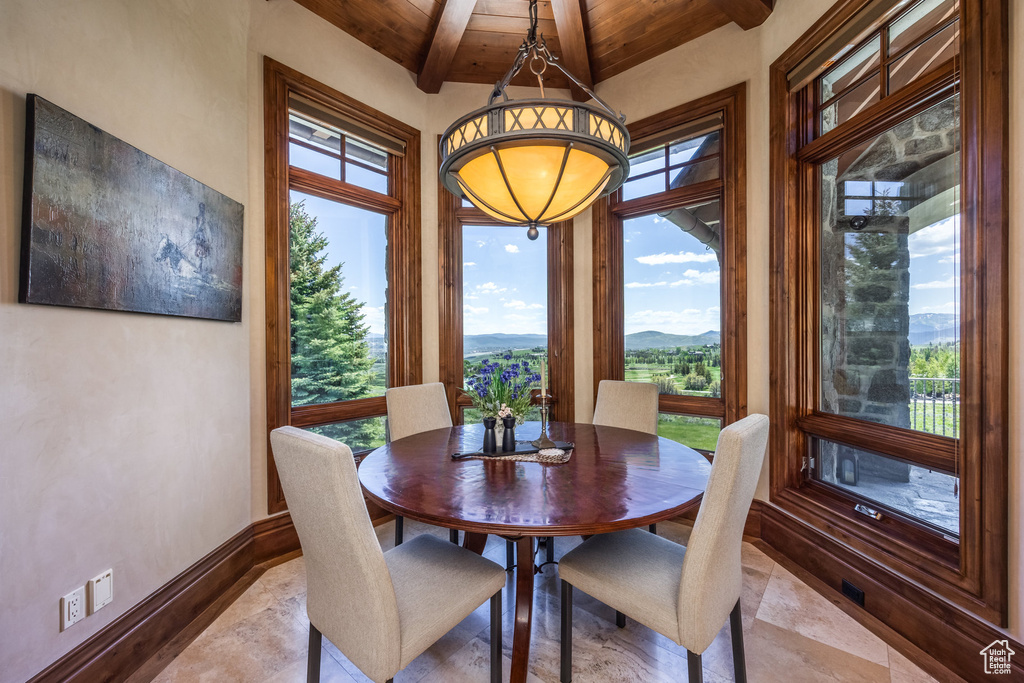 Dining area featuring a wood ceiling with exposed beams and a mountain view