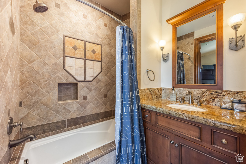 Bathroom with tiled shower / bath combo and vanity