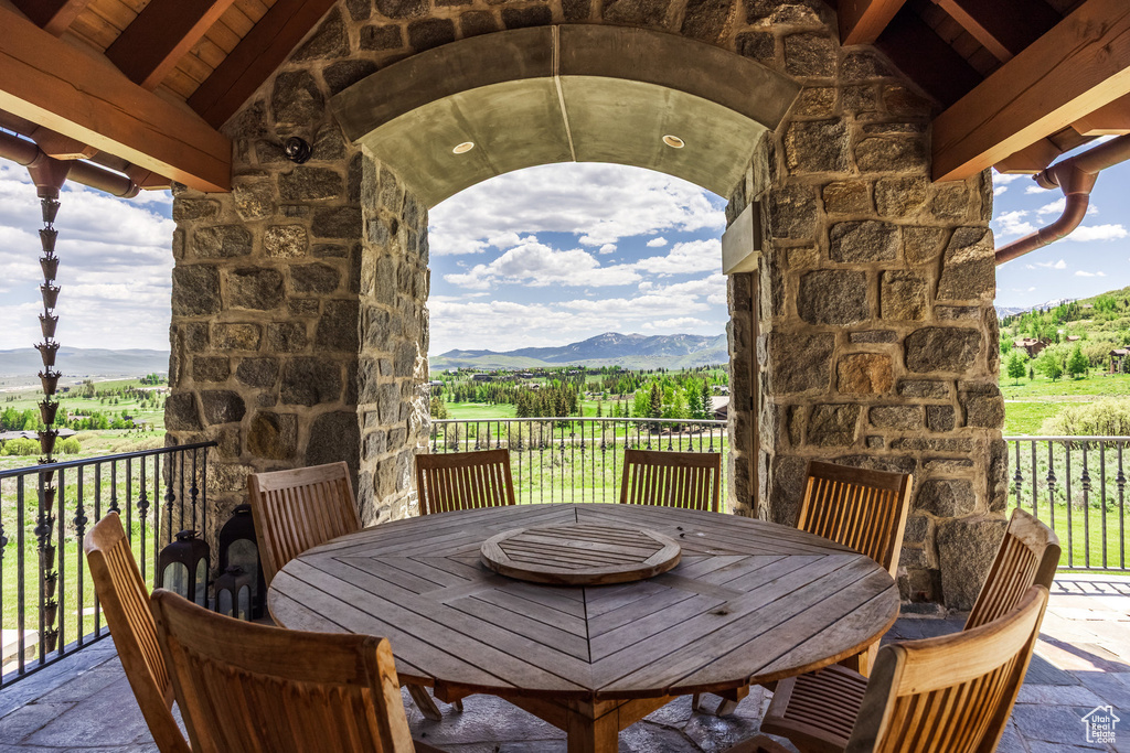 View of patio featuring a mountain view, outdoor dining area, and an outdoor stone fireplace