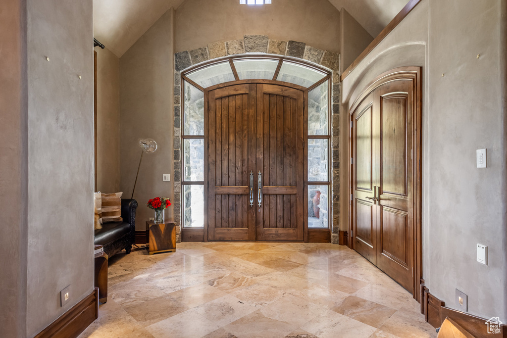 Foyer featuring vaulted ceiling and marble tiled flooring