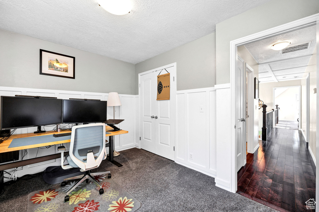 Office area with a textured ceiling and wainscoting
