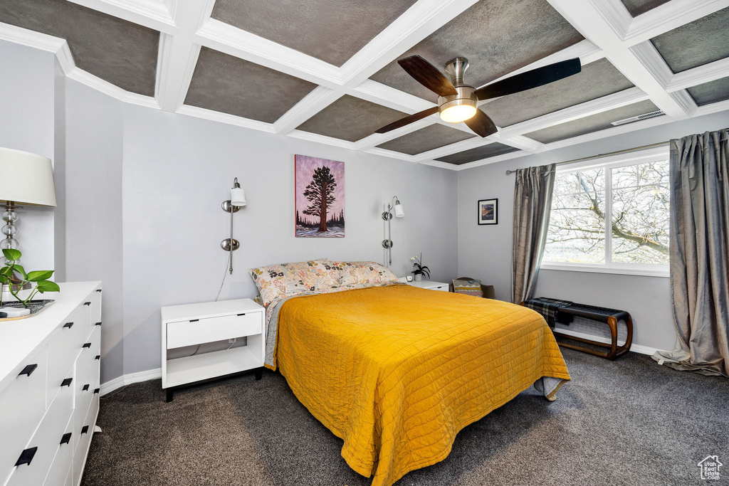 Bedroom with coffered ceiling, dark carpet, beamed ceiling, ceiling fan, and ornamental molding