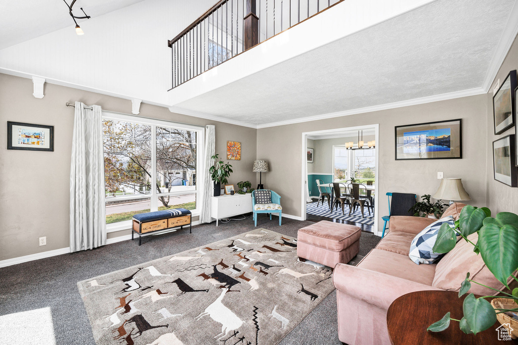 Carpeted living room featuring a chandelier, ornamental molding, and a high ceiling