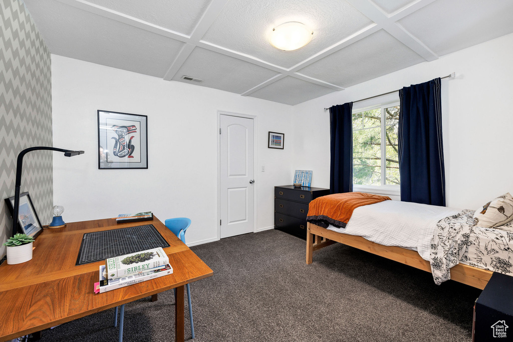 Carpeted bedroom featuring coffered ceiling, a desk, and beamed ceiling
