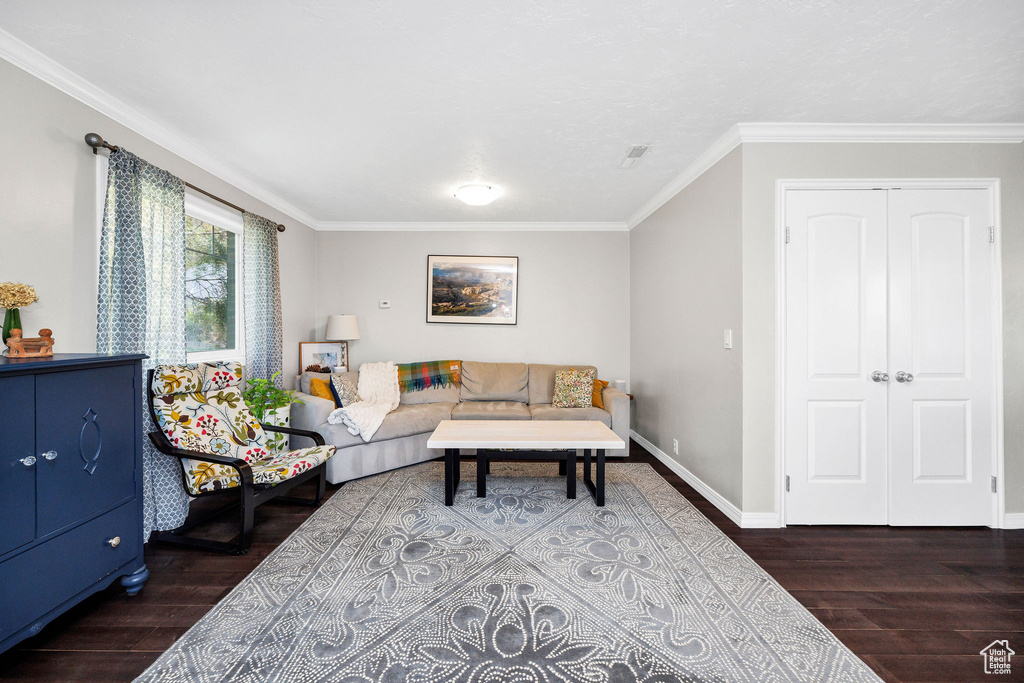 Living room with wood finished floors and crown molding