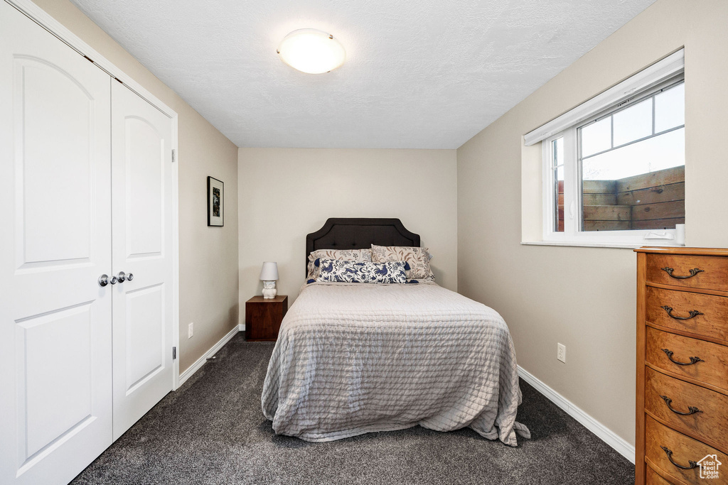 Carpeted bedroom with baseboards and a textured ceiling