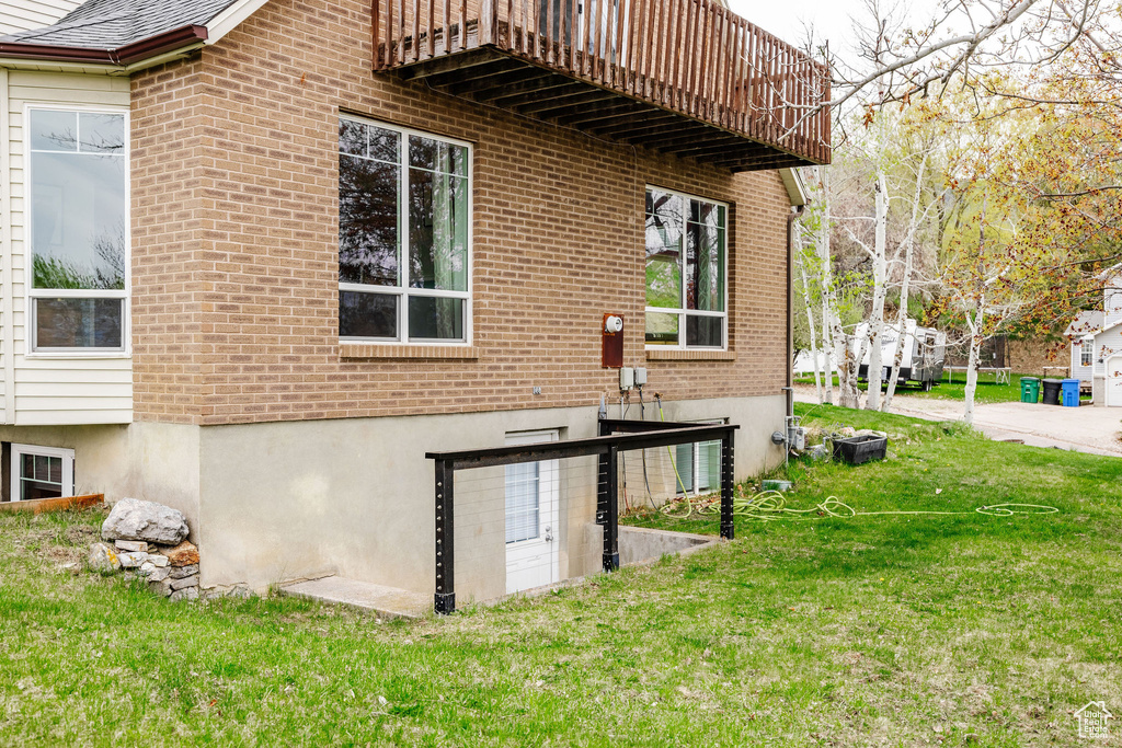 View of side of property with a lawn and brick siding