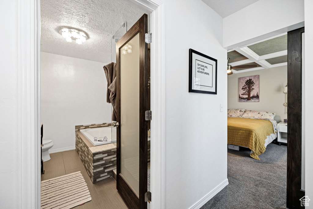 Hallway with a textured ceiling and baseboards