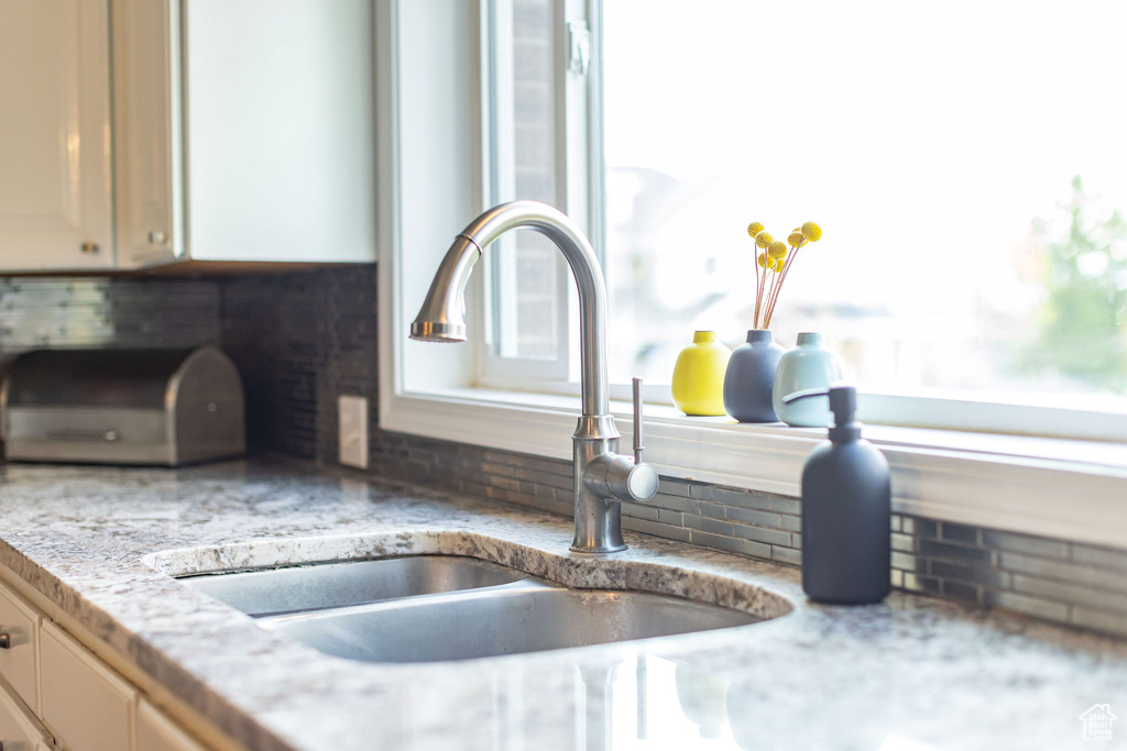 Kitchen view of a sink and tasteful backsplash