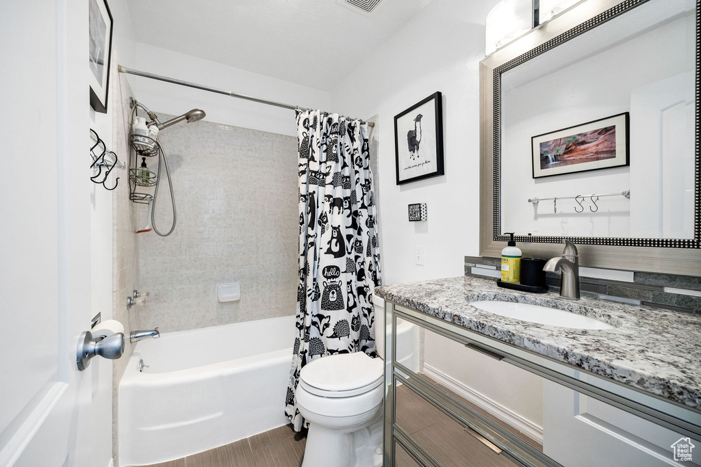 Full bathroom featuring vanity and shower / bathtub combination with curtain