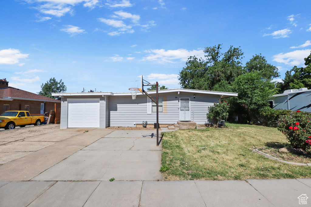 View of front of home with a front yard and concrete driveway