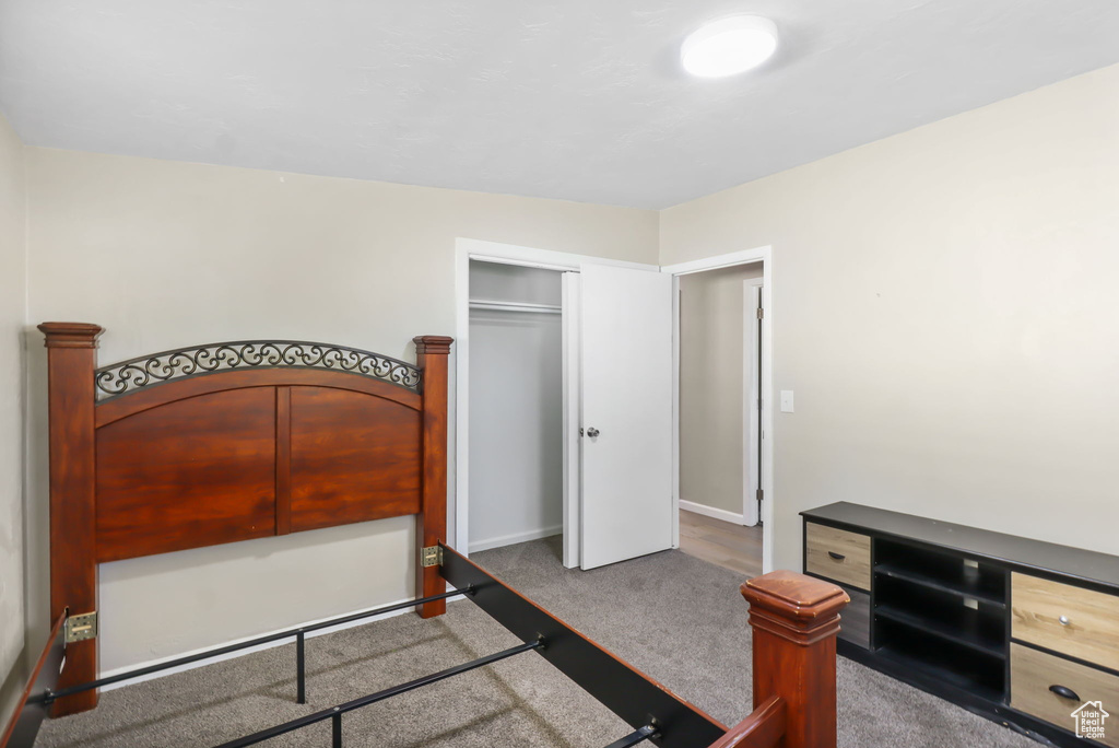 Carpeted bedroom with a closet and baseboards