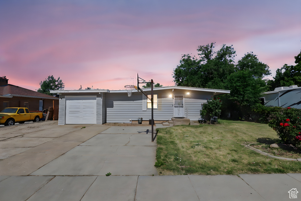 Single story home featuring a yard, driveway, and a garage