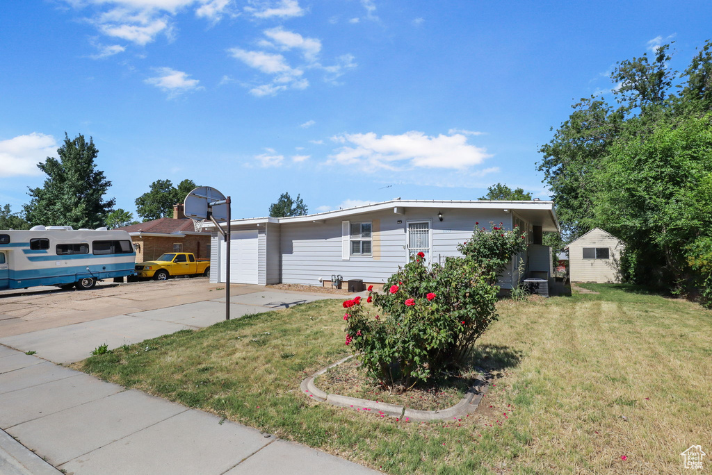 View of front of house featuring a front yard, driveway, and a garage