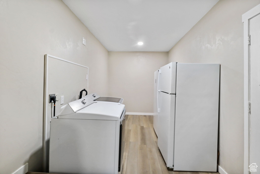 Laundry area with washing machine and dryer, light wood-style flooring, and recessed lighting