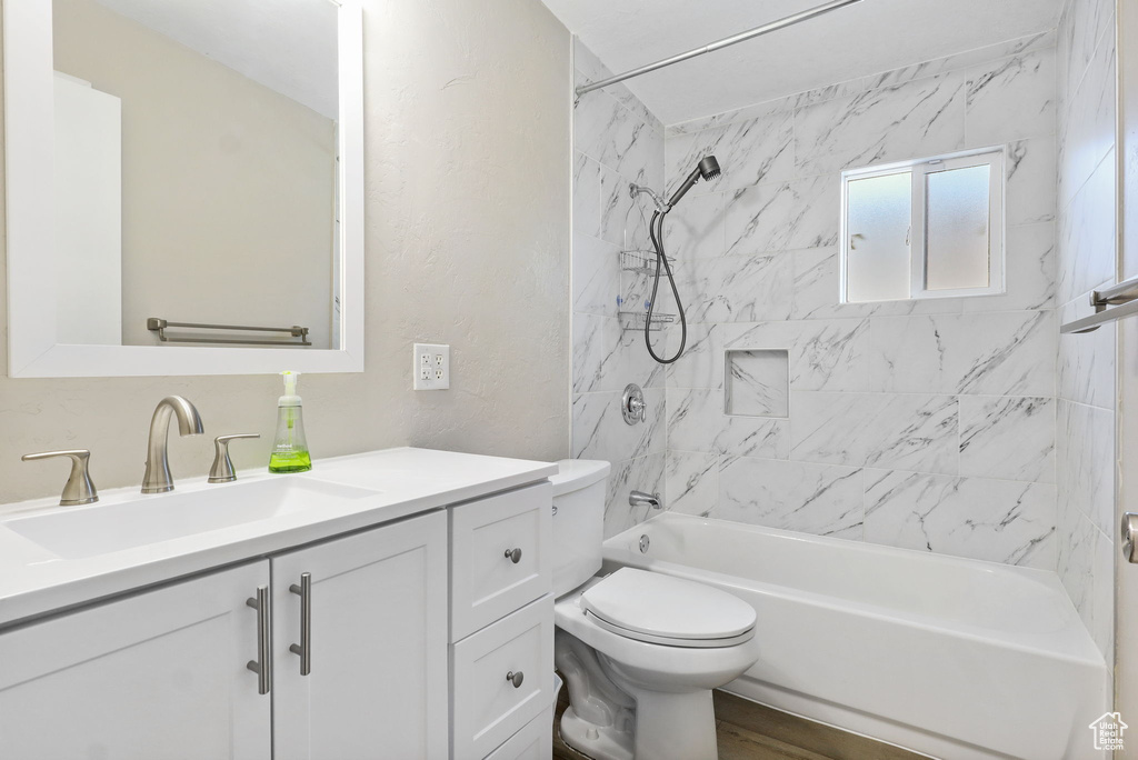 Bathroom featuring vanity, bathing tub / shower combination, and a textured wall