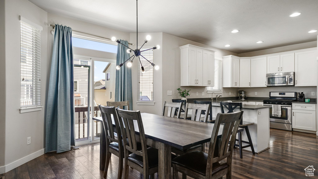 Dining area with a chandelier, dark wood-style floors, and recessed lighting