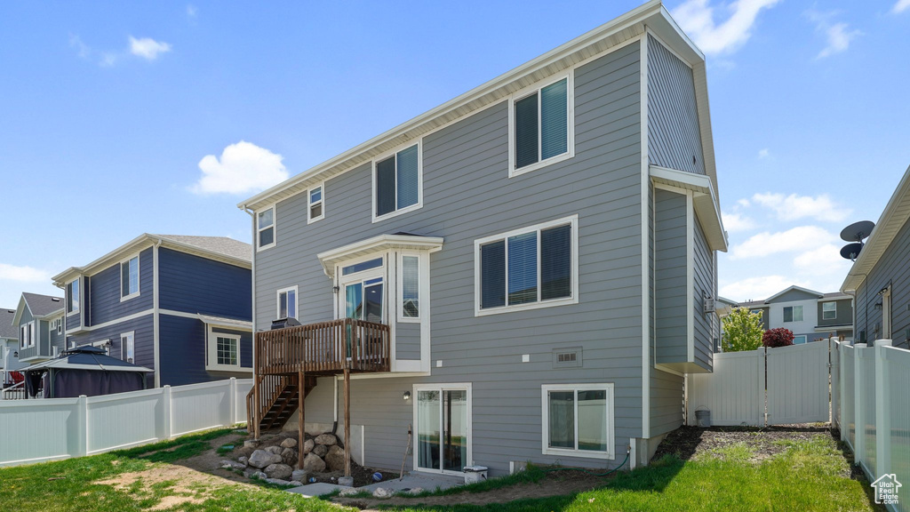 Back of property featuring stairway, a fenced backyard, a deck, and a gate