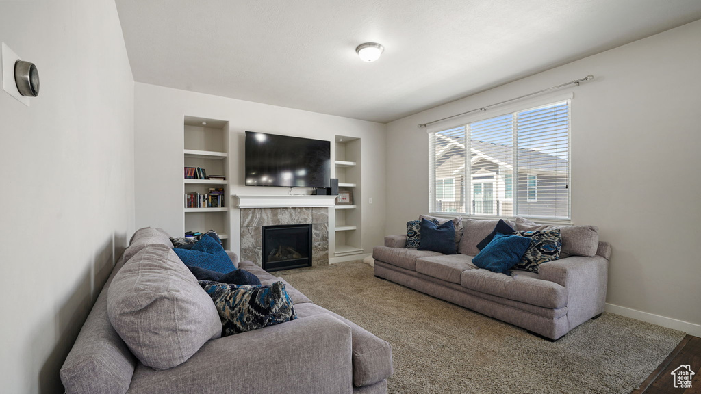 Living area with built in features and a tiled fireplace