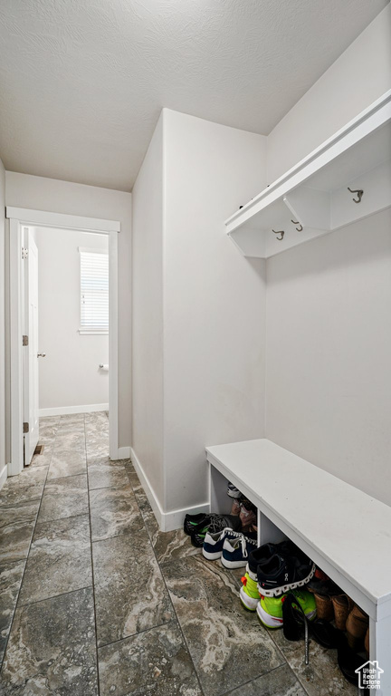 Mudroom with baseboards and stone finish floors