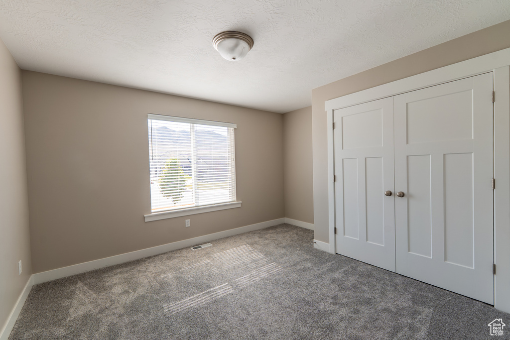 Unfurnished bedroom with carpet flooring and a closet