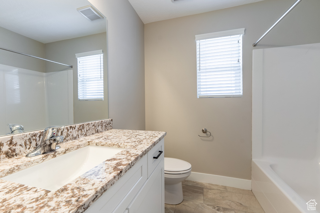 Bathroom with marble finish floors, vanity, and tub / shower combination