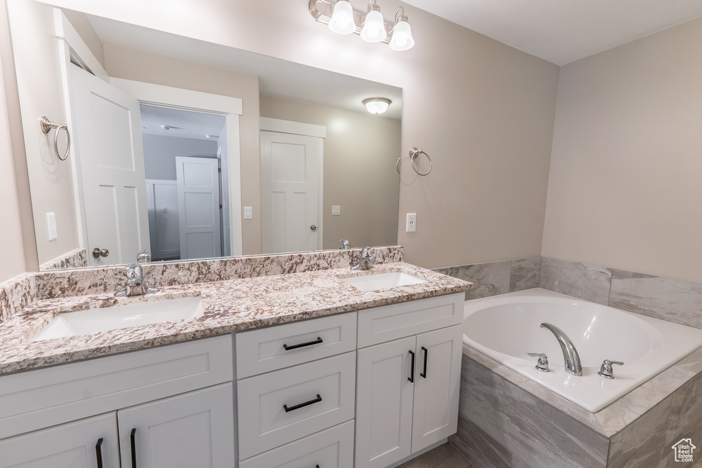 Full bathroom featuring double vanity and a garden tub
