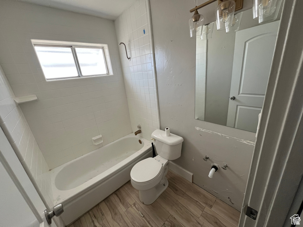 Bathroom featuring shower / bath combination and wood finished floors