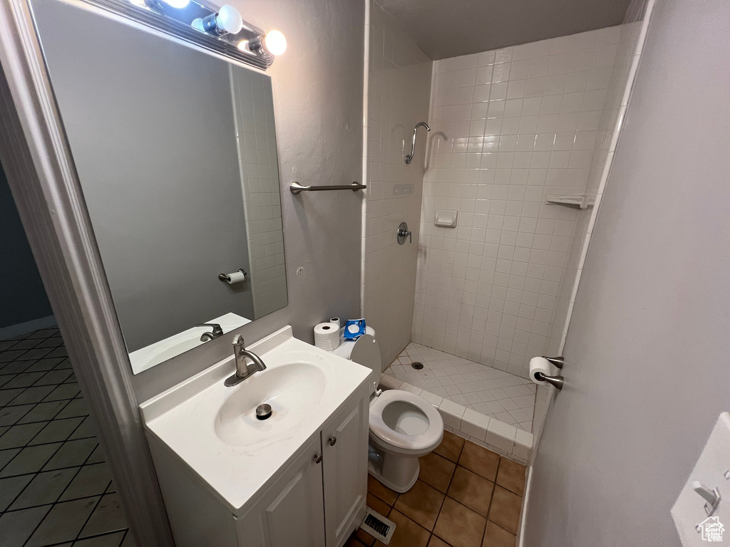 Full bathroom featuring tile patterned floors, a shower stall, and vanity