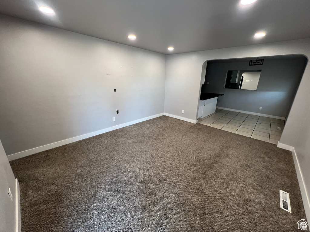 Unfurnished room with carpet flooring, recessed lighting, tile patterned flooring, and arched walkways