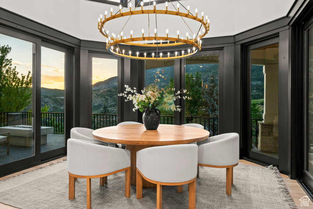 Dining area featuring a chandelier, wood finished floors, french doors, and a mountain view