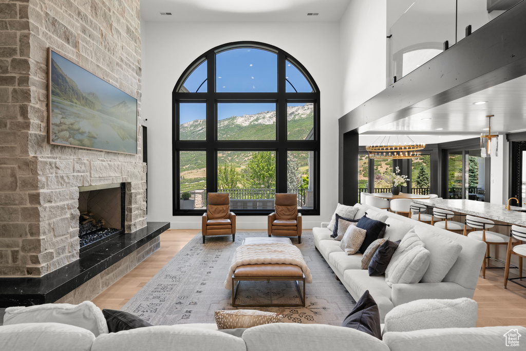 Living room featuring a fireplace, wood finished floors, and a high ceiling