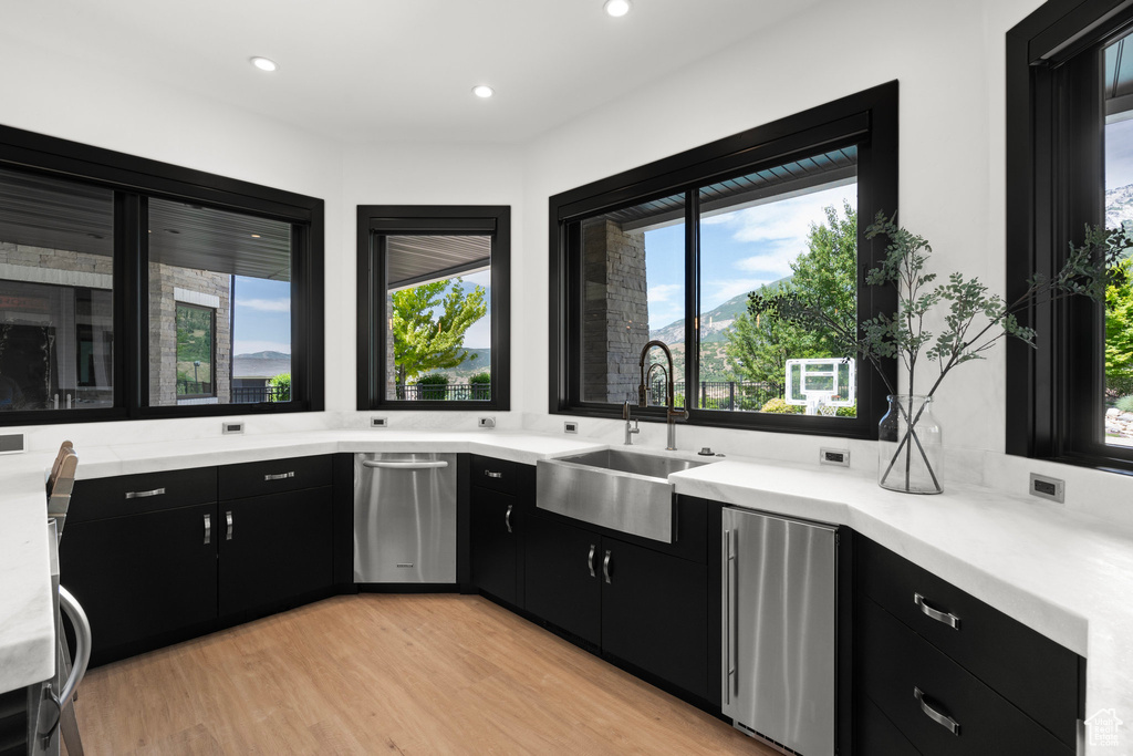 Kitchen featuring dark cabinetry, stainless steel appliances, light countertops, plenty of natural light, and recessed lighting