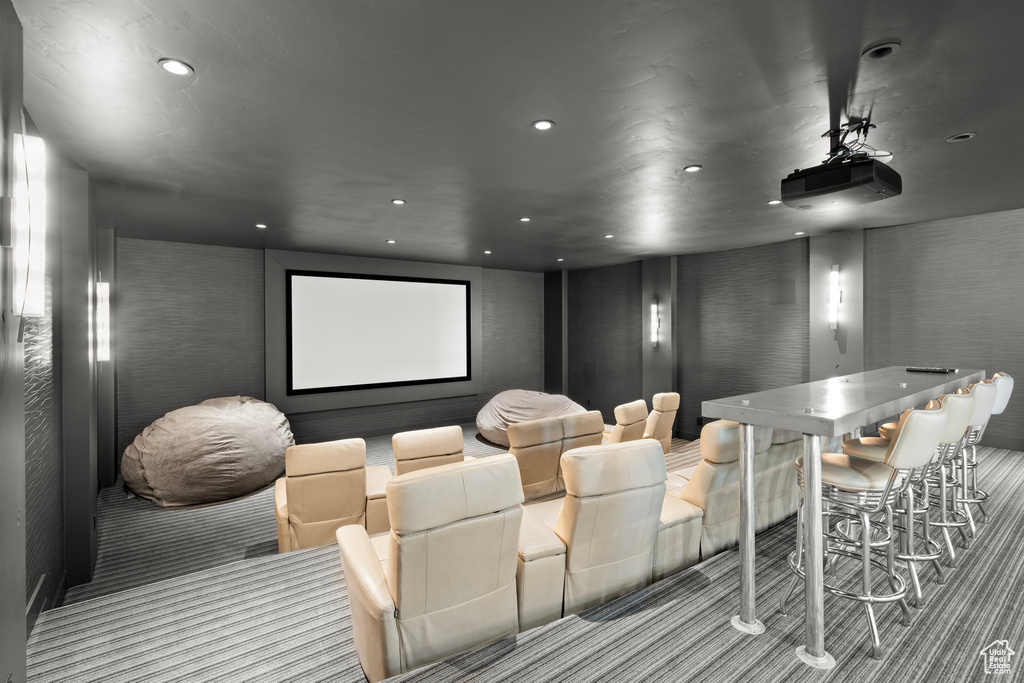 Carpeted cinema room with a bar and recessed lighting