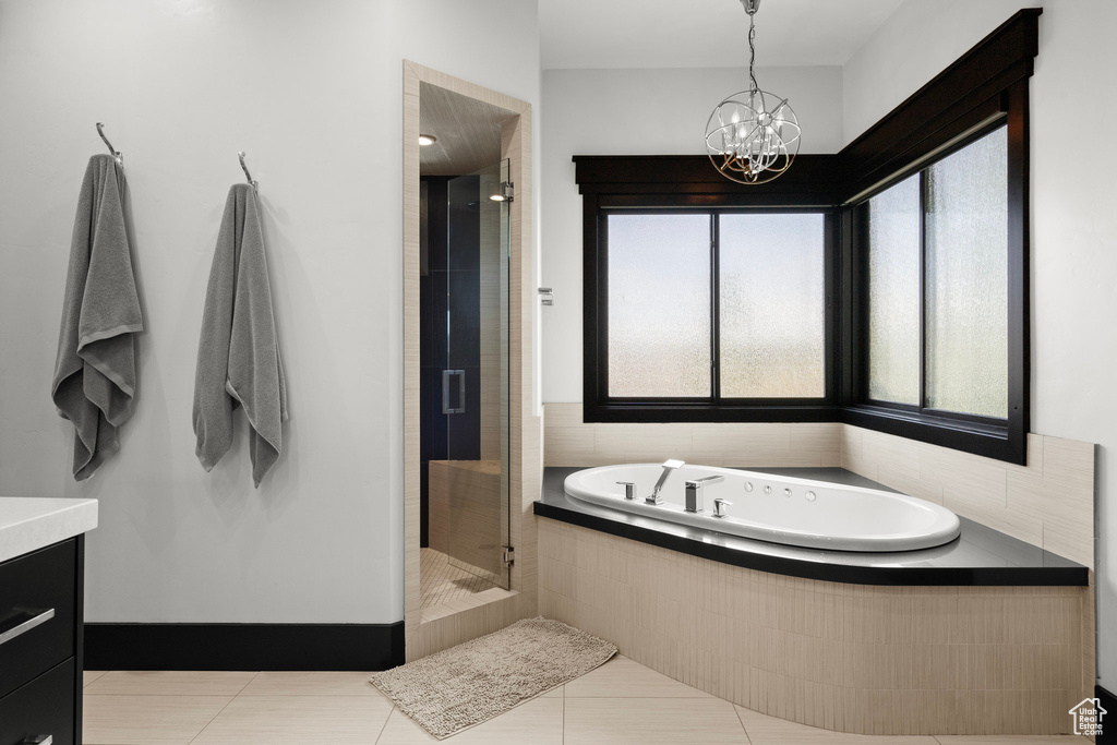 Full bath featuring a bath, a shower stall, tile patterned floors, a chandelier, and vanity