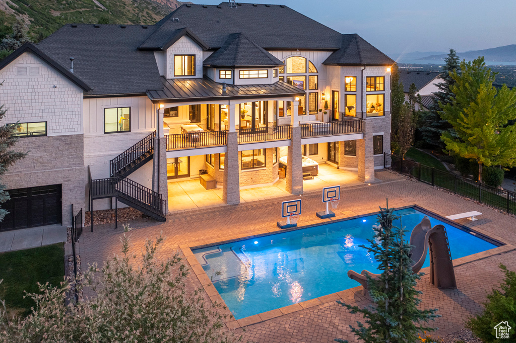 Back of property with a standing seam roof, stairway, a patio, a metal roof, and roof with shingles
