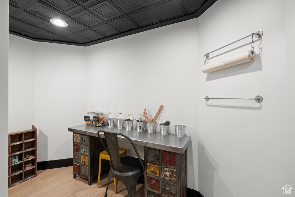 Office area with light wood-style flooring and an ornate ceiling