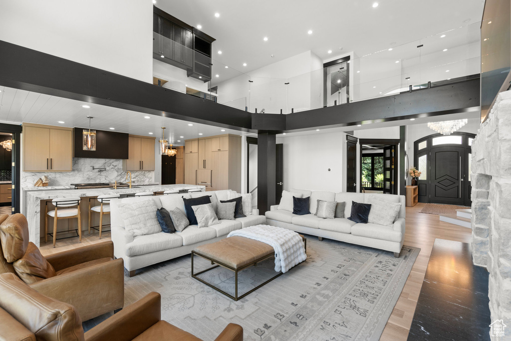Living area featuring light wood-style flooring, recessed lighting, and a high ceiling