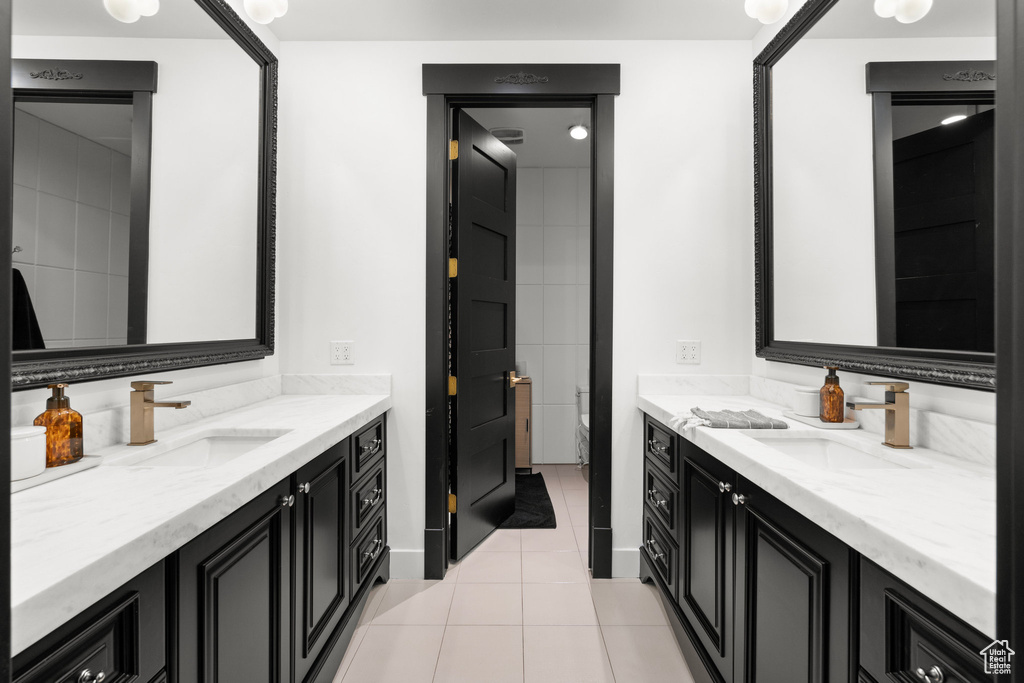 Bathroom featuring two vanities and tile patterned flooring