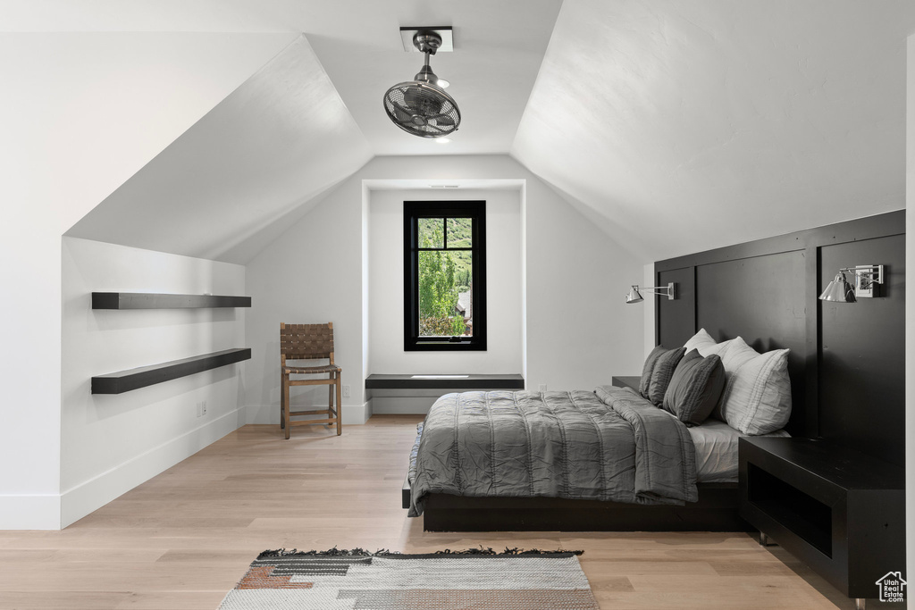 Bedroom with light wood-type flooring and vaulted ceiling