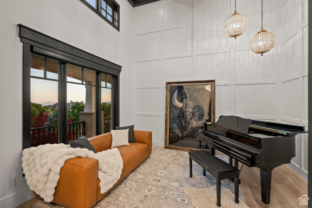 Living area with a decorative wall, a towering ceiling, and wood finished floors