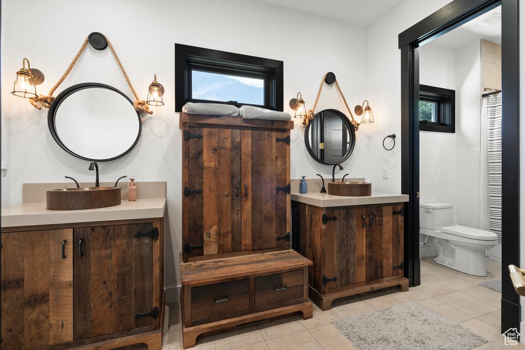 Bathroom featuring two vanities and toilet