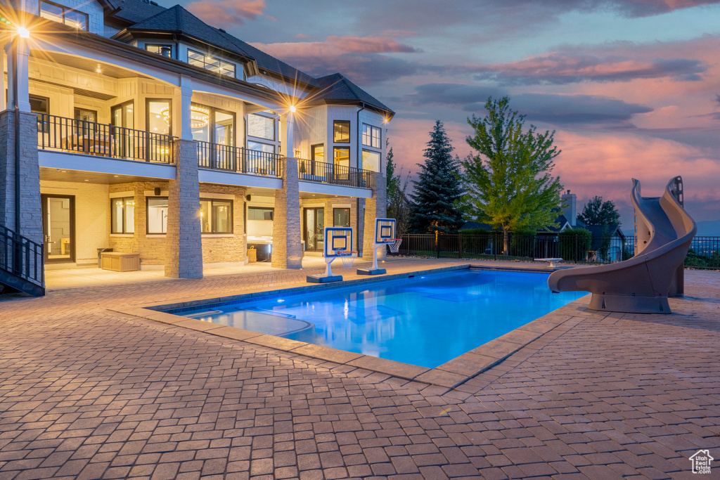 View of swimming pool featuring a water slide and a patio area