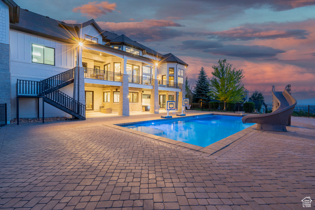 View of pool featuring a water slide, a patio, and stairway