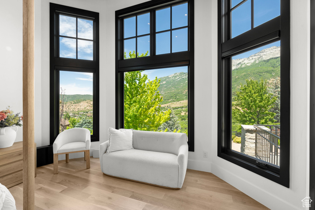 Living area featuring a towering ceiling, light wood finished floors, and a mountain view